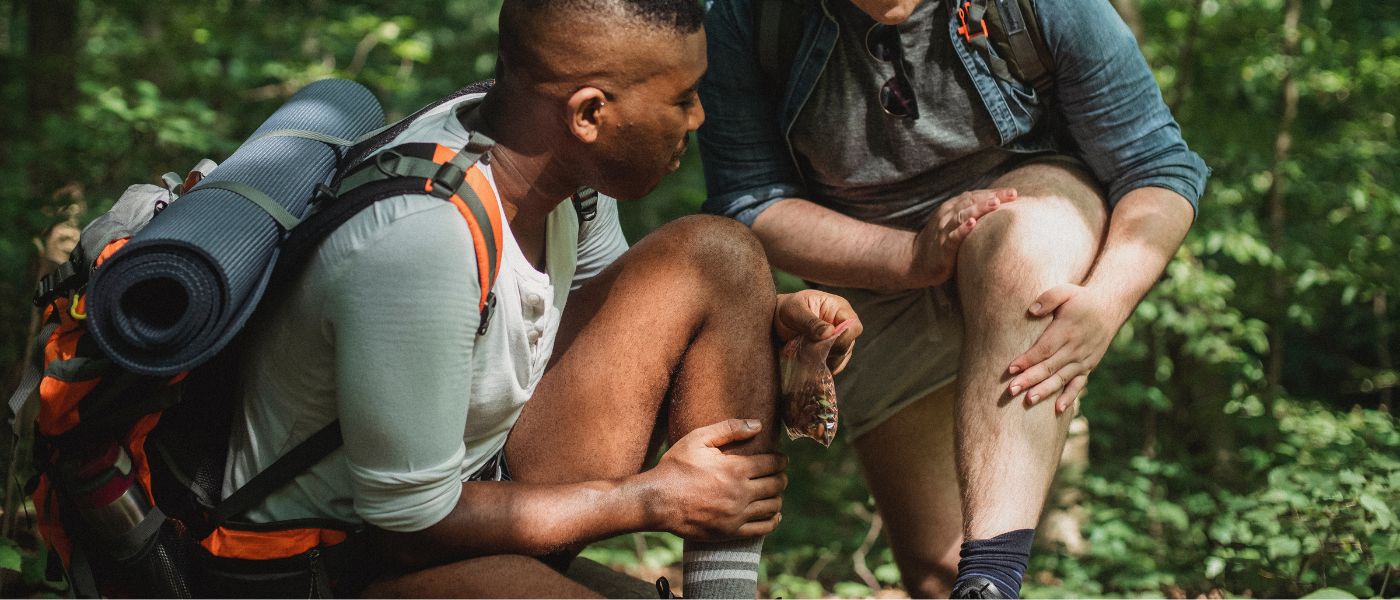 Ein Mann mit Hut und Rucksack sitzt im Freien, möglicherweise beim Wandern. Perfekt für Outdoor-Aktivitäten, erhältlich bei alpinloacker.com.