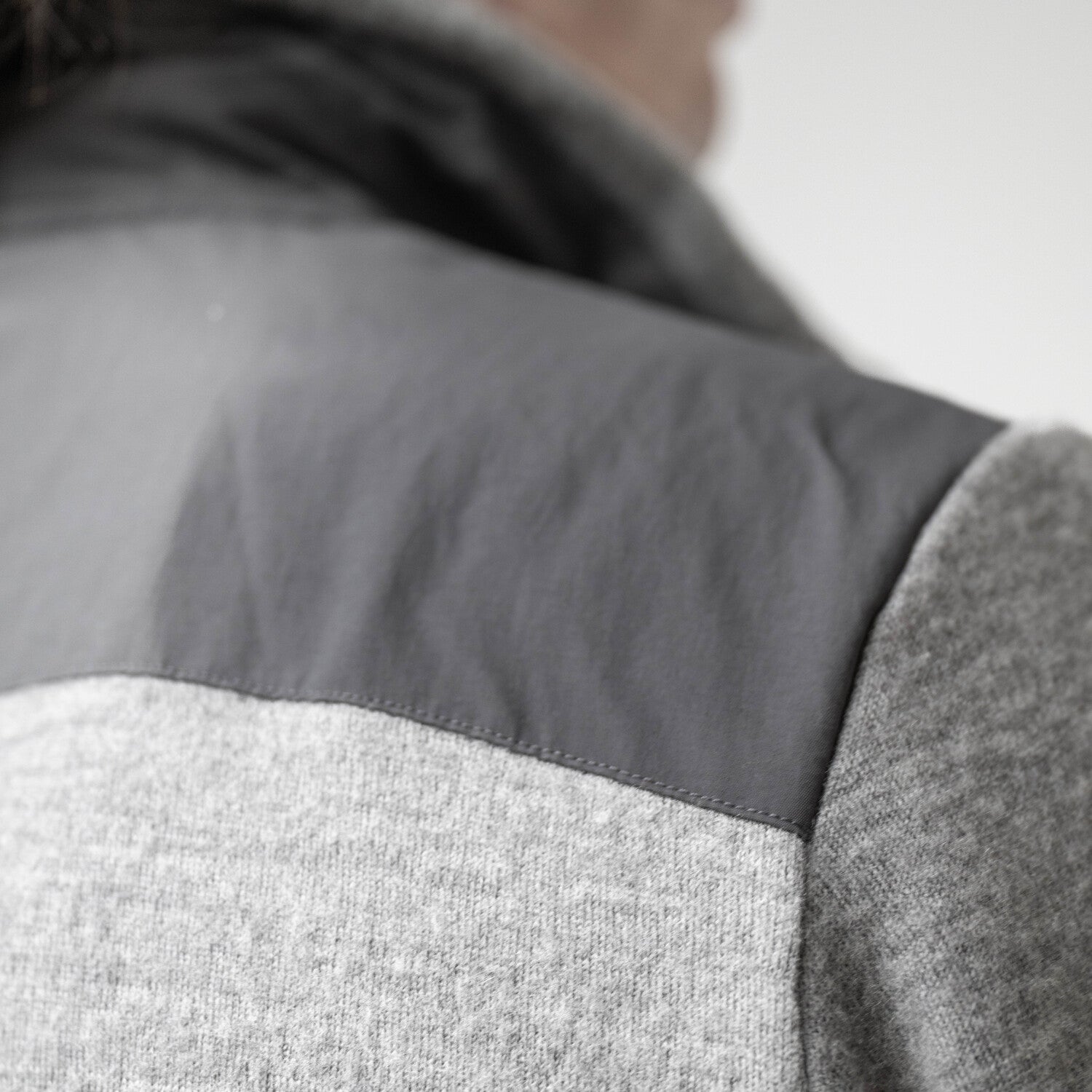 Nahaufnahme der Merino Fleecejacke Herren grau, auf der die robuste Textilschicht an der Schulter gezeigt wird