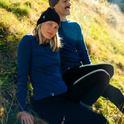 Pärchen sitzt in Meirno Sets in der Natur und genießen den weichen Wollstoff - die perfekte untere Schicht für die kühlere Tage.