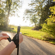 Person befestigt Klettverschluss am Teleskop Nordic Walking Stock aus Aluminium von Alpin Loacker, ideal für komfortables und vielseitiges Wandern. Ergonomischer Griff und verstellbare Länge.