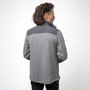 Model trägt grauen Merino Fleece aus 100% Merinowolle, mit moderner Doppel-Fleece Struktur und robusten Schulterpartien
