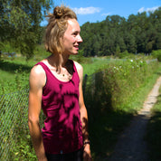 Person trägt das Merino Tank Top Damen 150g/m2 draußen, ideal für Outdoor-Aktivitäten dank CORESPUN-Technologie, die Merinowolle mit synthetischen Fasern kombiniert.