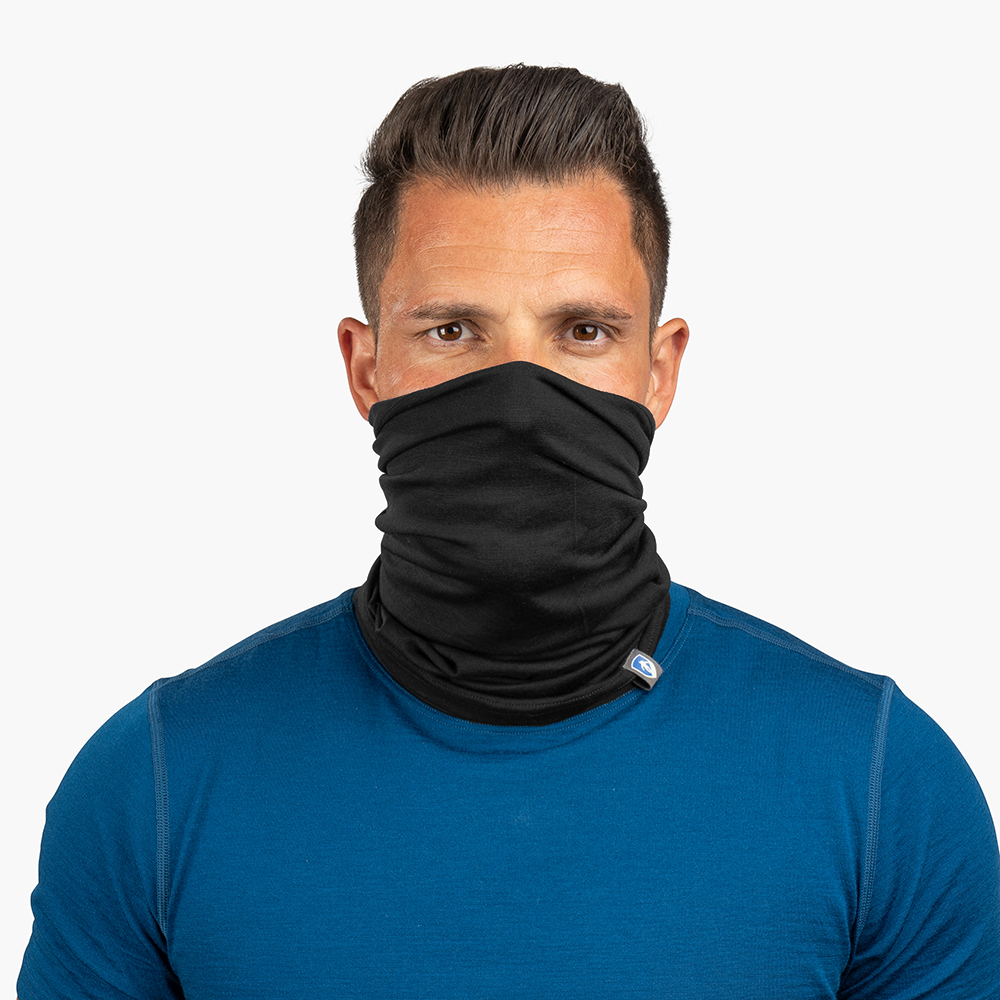 Erwachsener Mann trägt Merino Halstuch Herren & Damen, ein schwarzes, atmungsaktives Multifunktionstuch aus Merinowolle, ideal für Outdoor-Aktivitäten.