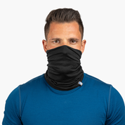 Erwachsener Mann trägt Merino Halstuch Herren & Damen, ein schwarzes, atmungsaktives Multifunktionstuch aus Merinowolle, ideal für Outdoor-Aktivitäten.