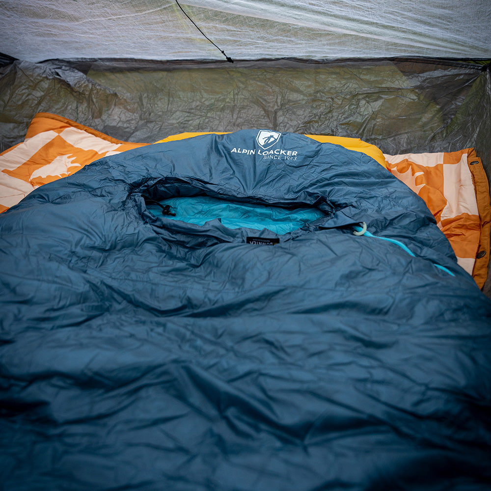 UL Down Pro 3 Daunenschlafsack im Zelt mit orangefarbener Unterlage, ideal für Mehrtagestouren und Camping, leicht und umweltfreundlich.