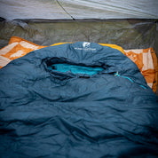 UL Down Pro 3 Daunenschlafsack im Zelt mit orangefarbener Unterlage, ideal für Mehrtagestouren und Camping, leicht und umweltfreundlich.