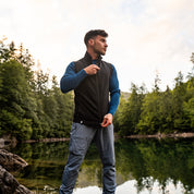 Mann am See mit Merino Weste Herren 270 g/m2, zippend. Ideal als Midlayer für Outdoor-Aktivitäten, bietet Temperaturregulierung und Komfort.