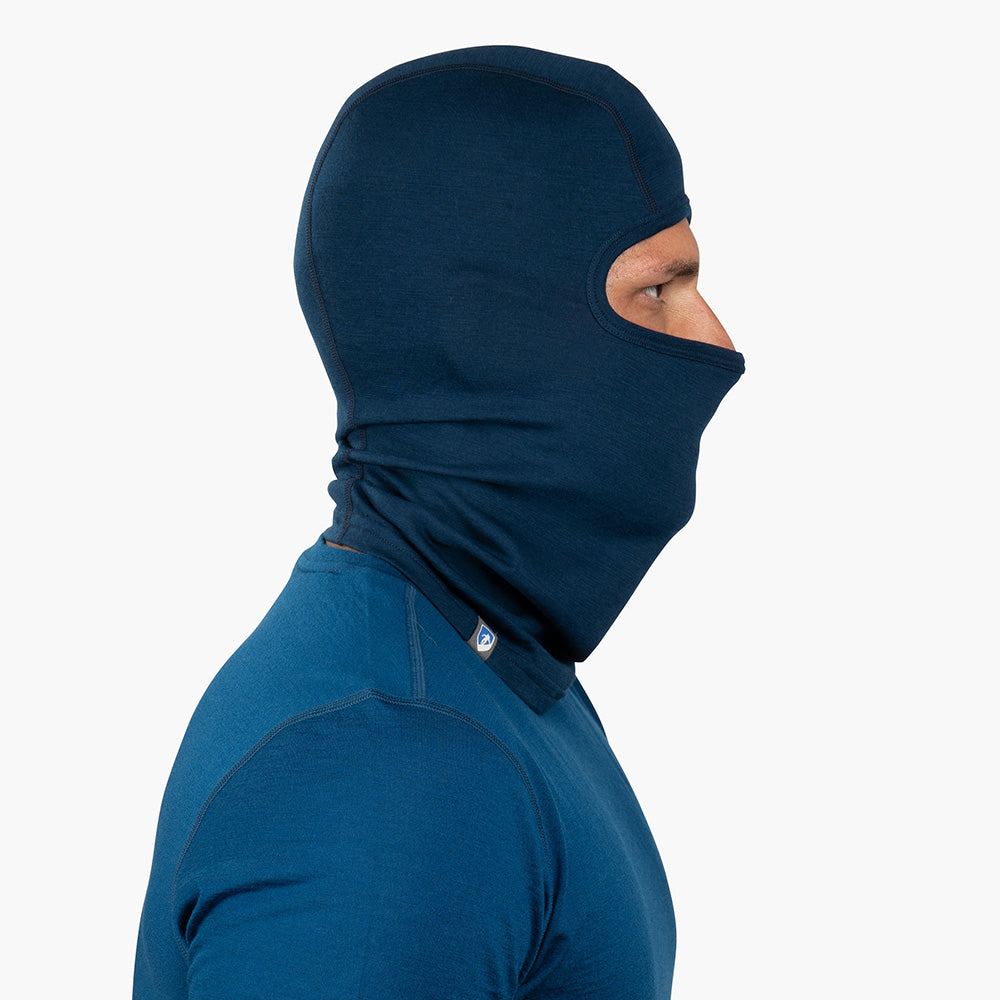 Person im Profil trägt eine Merino Sturmhaube und Skimaske Herren & Damen, kombiniert mit passendem Basisschicht-Oberteil, ideal für Outdoor-Aktivitäten bei kaltem Wetter.
