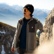 Model trägt grauen Merino Fleece aus 100% Merinowolle am Berg, der perfekte Midlayer für kühlere Tage