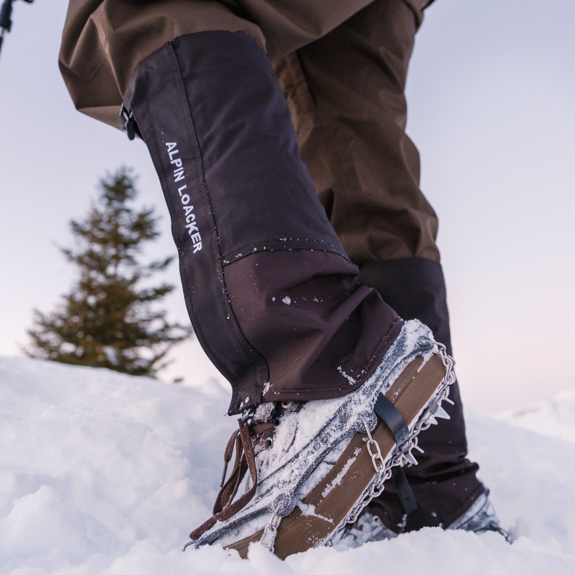 Mann trägt Gamschen und Spikes im Schnee von Alpin Loacker, perfekt für Schnee und Nässe