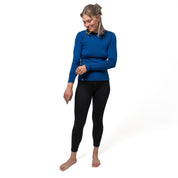 Model trägt 100% Merino Set und schaut auf ihren Ärmel des blauen Oberteils
