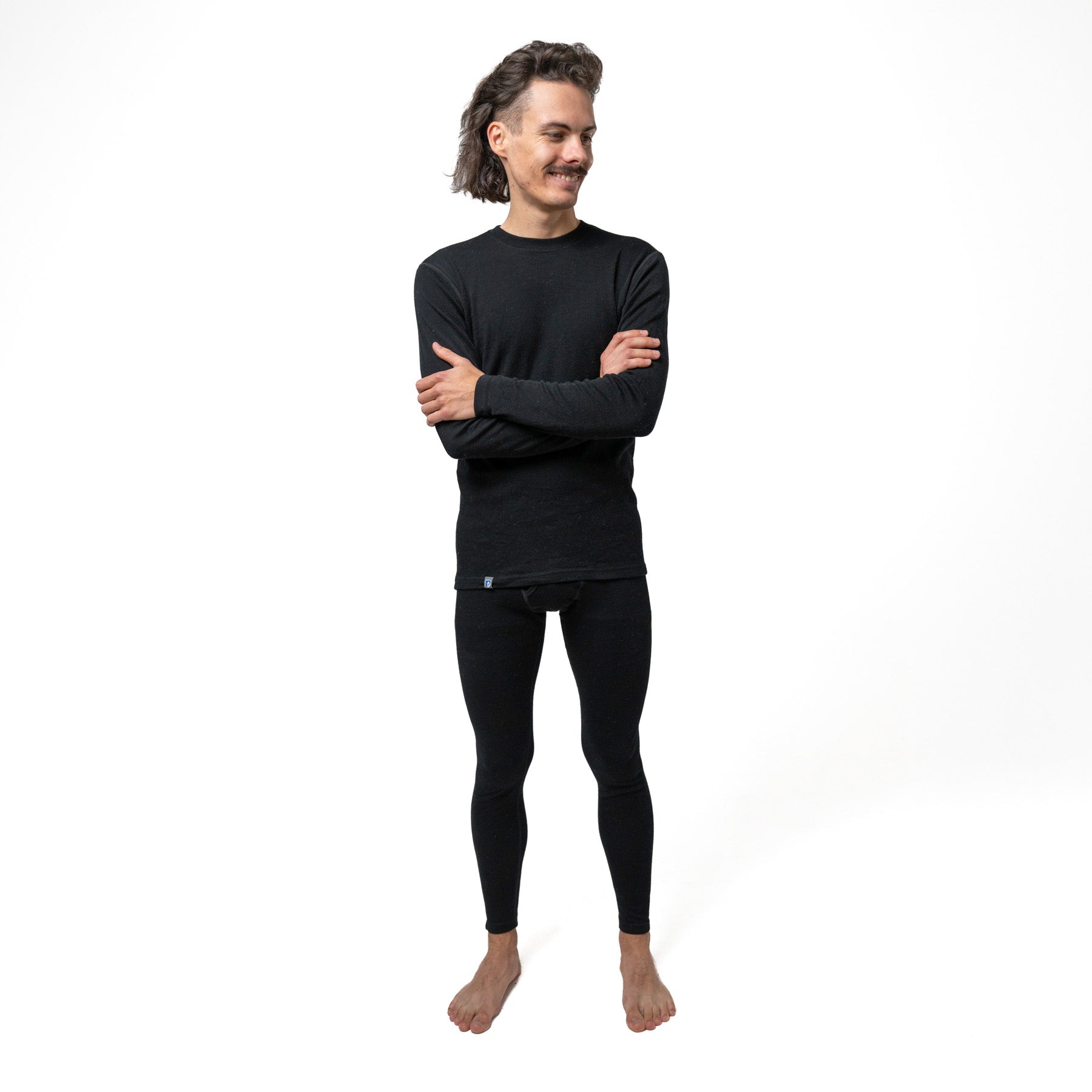 Mann trägt das 100% Merinowolle Set schwarz von Alpin Loacker, perfekt als Baselayer für die kalte Jahreszeit