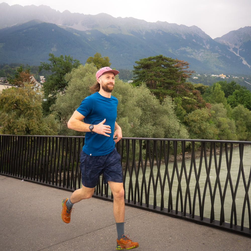 m2 auf Brücke vor Bergkulisse, ideal für Outdoor-Aktivitäten durch temperaturregulierende und geruchsneutrale Eigenschaften.