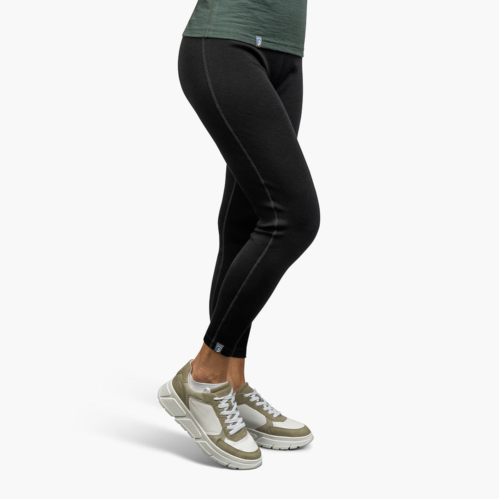 m2 getragen mit weißen, olivgrünen Sneakers, zeigt Komfort und Funktionalität der atmungsaktiven, temperaturregulierenden Merinowolle für Outdoor-Abenteuer.