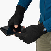 Person hält Smartphone, trägt fingerlose Merino Handschuhe Damen & Herren von Alpin Loacker, ideal für Outdoor-Aktivitäten, bietet Wärme und Geschicklichkeit.