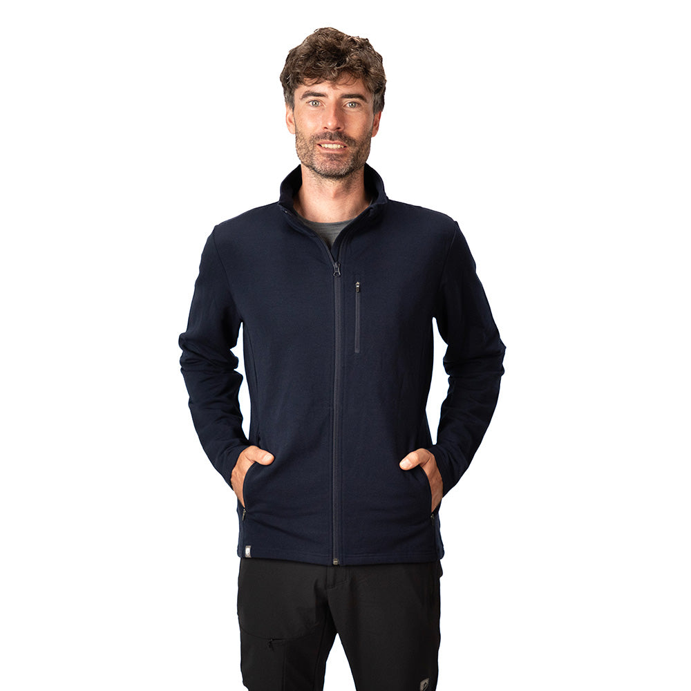 Mann trägt Merino Jacke Herren 270 g/m² mit Reißverschlusstaschen, ideal für Outdoor-Aktivitäten, kombiniert Wärme und Flexibilität. Perfekt für Abenteuer und Alltag.