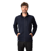 Mann trägt Merino Jacke Herren 270 g/m² mit Reißverschlusstaschen, ideal für Outdoor-Aktivitäten, kombiniert Wärme und Flexibilität. Perfekt für Abenteuer und Alltag.