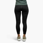 Lange Merino Unterhose Damen 230 g/m2, getragen unter dunklem T-Shirt, betont Komfort und Funktionalität für Outdoor-Abenteuer.