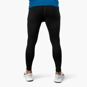Mann in schwarzen Lange Merino Unterhose Herren 230 g/m2 und weißen Sneakers, ideal für Outdoor-Aktivitäten dank Merinowolle-Komfort und Atmungsaktivität.