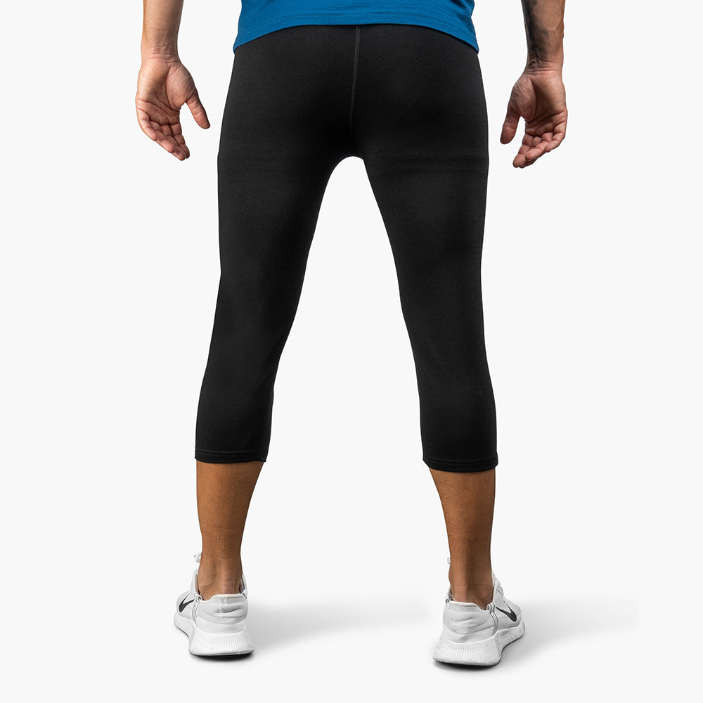 Rückansicht einer Person in Alpin Loacker 3/4 Merino Unterhose für Herren, kombiniert mit Nike-Schuhen, ideal für Outdoor-Aktivitäten und als Midlayer.