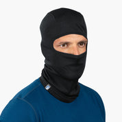 Person trägt Merino Sturmhaube und Skimaske Herren & Damen, die Gesicht und Kopf bedeckt, mit Augen- und Nasenöffnung, ideal für Outdoor-Aktivitäten bei kaltem Wetter.