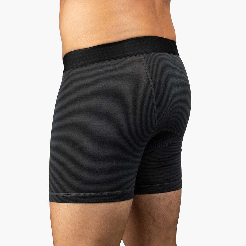 Merino Boxershorts Herren 150 g/m²: Dunkelgraue Boxer-Shorts mit CORESPUN-Technologie, ideal für Outdoor und Alltag, getragen von einer Person, unterer Torso sichtbar.