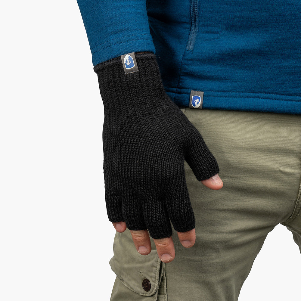 Fingerloser Merino Handschuh von Alpin Loacker an einer Hand mit blauem Top und olivgrüner Hose; ideal für Outdoor-Aktivitäten und urbanen Alltag.