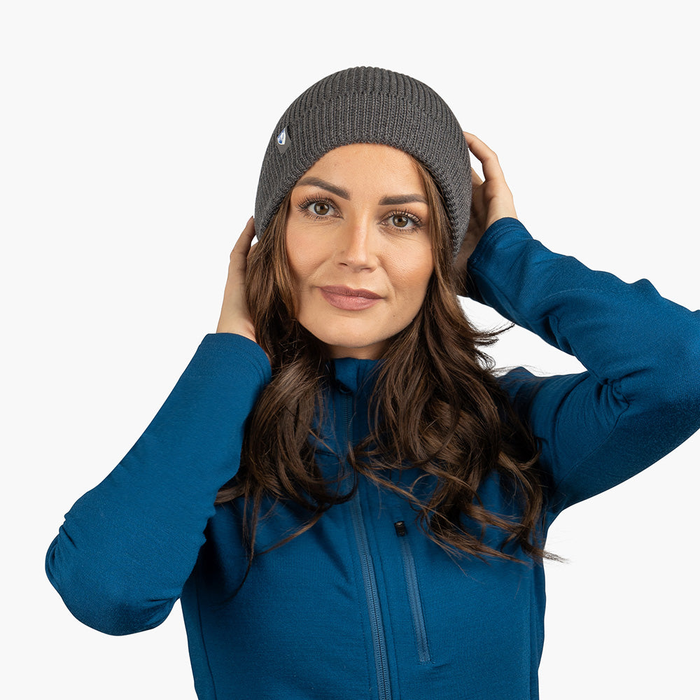 Junge Frau trägt Merino Mütze Herren & Damen Strick 230g/m2, ideal für Outdoor-Aktivitäten, aus 100% Merinowolle, temperaturregulierend und geruchsneutral.