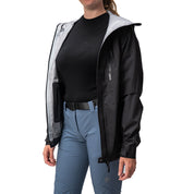 Person trägt eine offene 3 Lagen Damen Hardshell Regenjacke mit grauem Futter über schwarzem Shirt und blauen technischen Hosen. Perfekt für Outdoor-Aktivitäten.