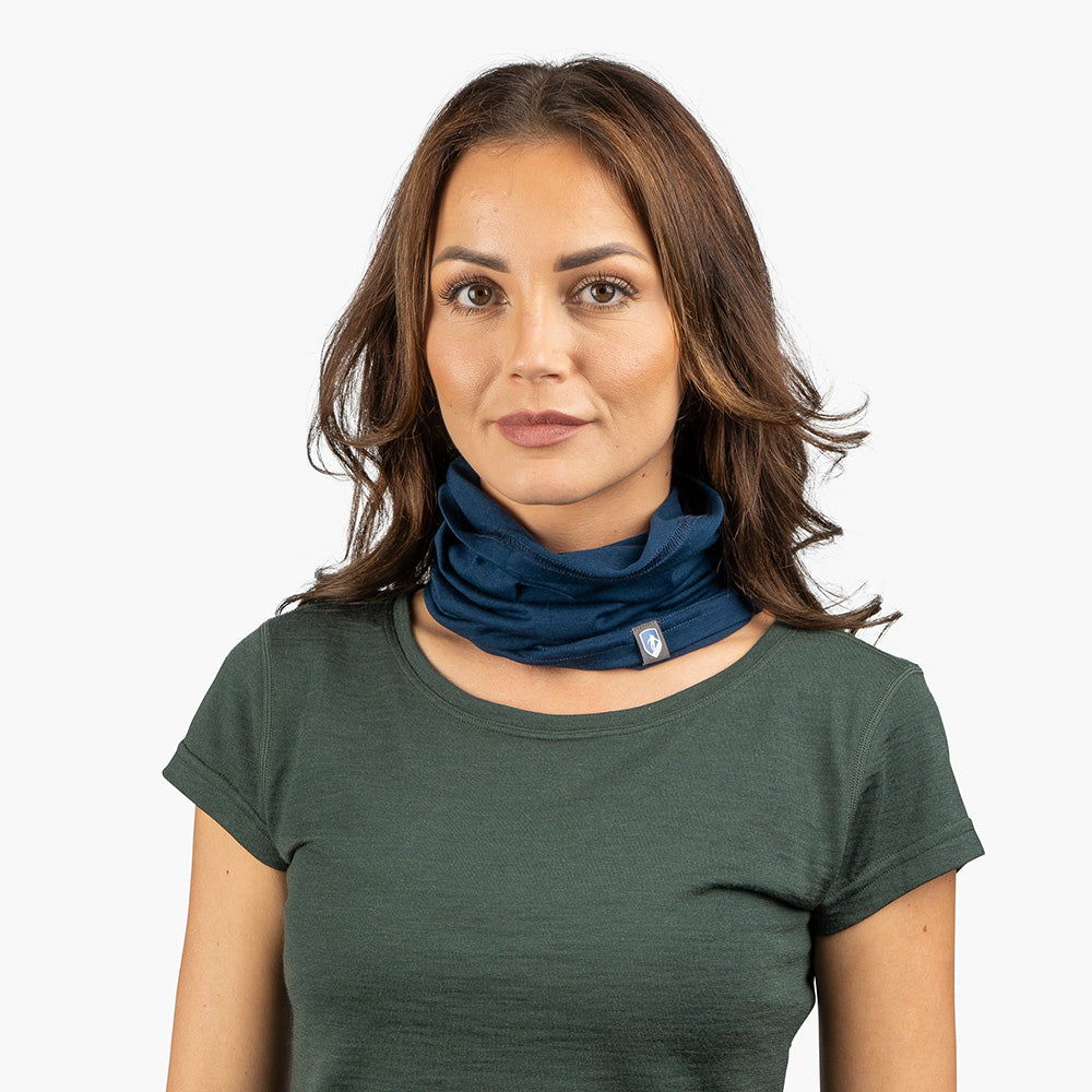 Junge Frau trägt ein Merino Halstuch Herren & Damen von Alpin Loacker, ein atmungsaktives, multifunktionales Schlauchtuch aus Merinowolle, ideal für Outdoor-Aktivitäten.