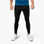 Männermodell trägt Lange Merino Unterhose Herren 230 g/m2 aus 100% Merinowolle, kombiniert mit weißen Sneakers, betont Komfort und Funktionalität für Outdoor-Abenteuer.