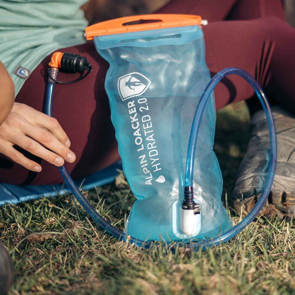 Alpin Loacker Trinkblase für Sommer + Winter auf Gras, mit Trinkschlauch und Beißventil, ideal für Outdoor-Aktivitäten wie Wandern und Trekking, ultraleicht und auslaufsicher.
