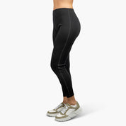 Lange Merino Unterhose Damen 230 g/m2, getragen mit weißen Sneakern, zeigt die Passform und Funktionalität für Outdoor-Abenteuer und Alltag.