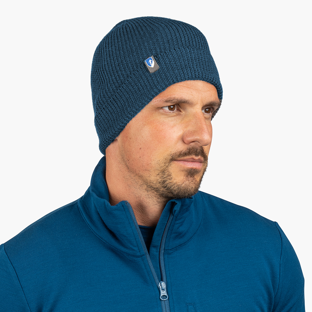 Merino Mütze Herren & Damen Strick 230g/m2: Seitliches Profil eines Mannes mit dunkelgrüner Merino-Mütze, ideal für Outdoor-Aktivitäten, aus 100% Merinowolle, temperaturregulierend.
