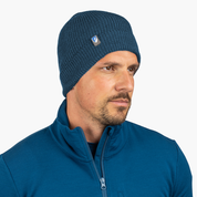 Merino Mütze Herren & Damen Strick 230g/m2: Seitliches Profil eines Mannes mit dunkelgrüner Merino-Mütze, ideal für Outdoor-Aktivitäten, aus 100% Merinowolle, temperaturregulierend.