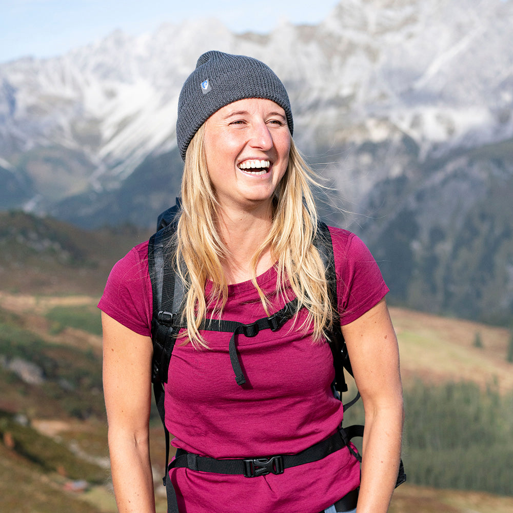Frau draußen mit Rucksack trägt Alpin Loacker Merino T-Shirt Damen 150g/m2, ideal für Outdoor-Aktivitäten durch Komfort und Strapazierfähigkeit der Corespun Merinowolle.