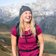 Frau draußen mit Rucksack trägt Alpin Loacker Merino T-Shirt Damen 150g/m2, ideal für Outdoor-Aktivitäten durch Komfort und Strapazierfähigkeit der Corespun Merinowolle.