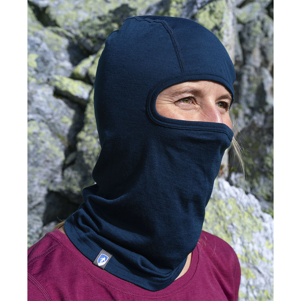 Person trägt Merino Sturmhaube und Skimaske Herren & Damen in felsiger Outdoor-Umgebung, zeigt nur Augen und Nase, ideal für kalte Outdoor-Aktivitäten.