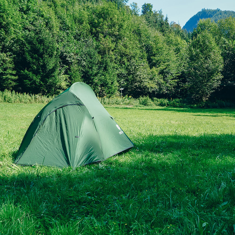 Cloud Pro Up 2 - 20D leichtes Zwei Mann Zelt im grünen Wiesencamp, umgeben von Bäumen und Bergen, ideal für Outdoor-Abenteuer und ultraleichtes Camping.