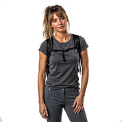 Frau in Outdoor-Kleidung mit schwarzem Rucksack trägt das Merino T-Shirt Damen 150g/m2, ideal für Komfort und Leistung bei Outdoor-Aktivitäten.