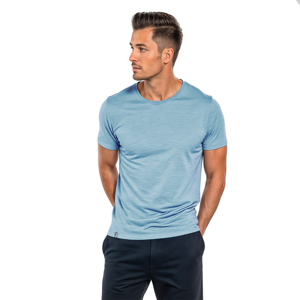 Junger Mann trägt Alpin Loacker Merino T-Shirt Herren 150 g/m2, ideal für Outdoor-Aktivitäten, mit Corespun-Merinowolle für Komfort und Haltbarkeit, vor weißem Hintergrund.