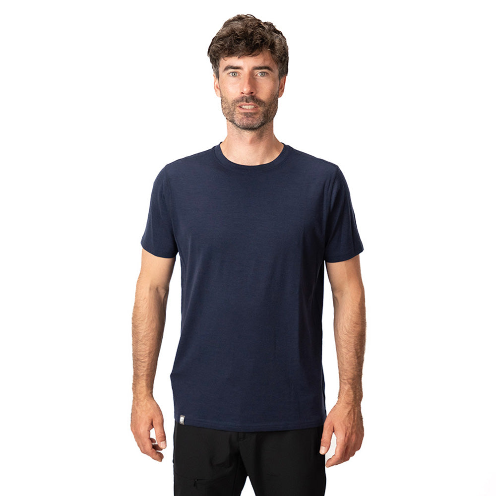 Mann trägt Merino T-Shirt Herren 150 g/m2, dunkelblau. Perfekt für Outdoor-Aktivitäten, kombiniert Komfort und Strapazierfähigkeit durch Corespun Merinowolle. Ideal für Alpinloacker Outdoor Shop.