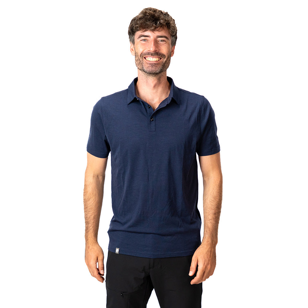 Mann trägt Merino Polo Shirt Herren, perfekt für Outdoor und Alltag, aus atmungsaktiver, temperaturregulierender Merinowolle. Elegantes Design, passend zu unterschiedlichen Anlässen.