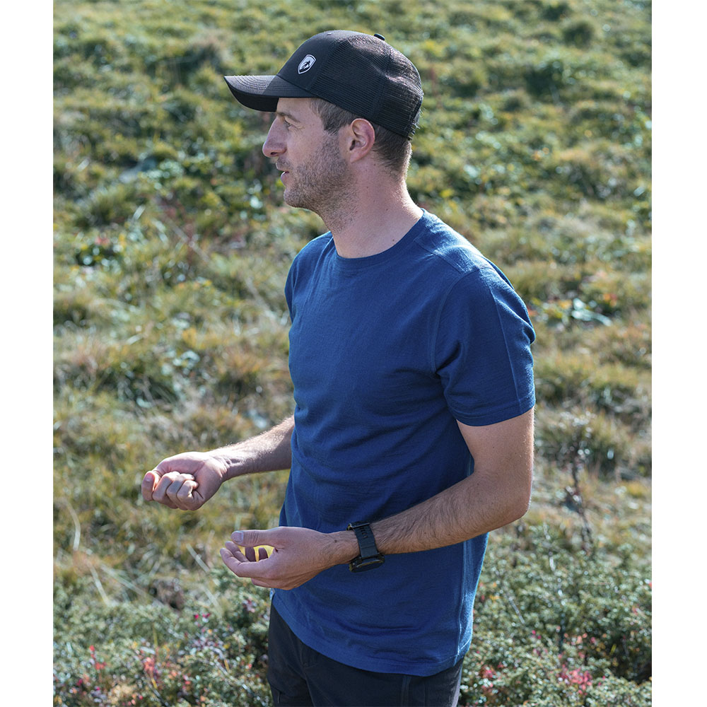 Person im Profil mit 100% Merino T-Shirt Herren 180 g/m2 von Alpin Loacker, gestikulierend auf einer Wiese. Ideal für Outdoor-Aktivitäten und Alltag.