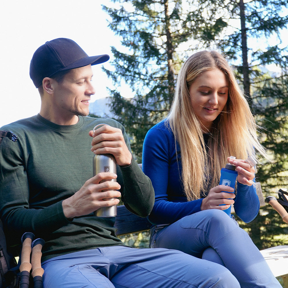 m2, machen eine Pause im Wald mit Wanderstöcken und Wasserflaschen.
