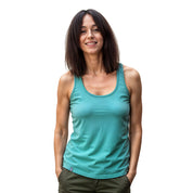 Junge Frau im Merino Tank Top Damen 150g/m2, lässig posierend. Ideal für Outdoor-Aktivitäten dank CORESPUN-Technologie für Komfort und Langlebigkeit.