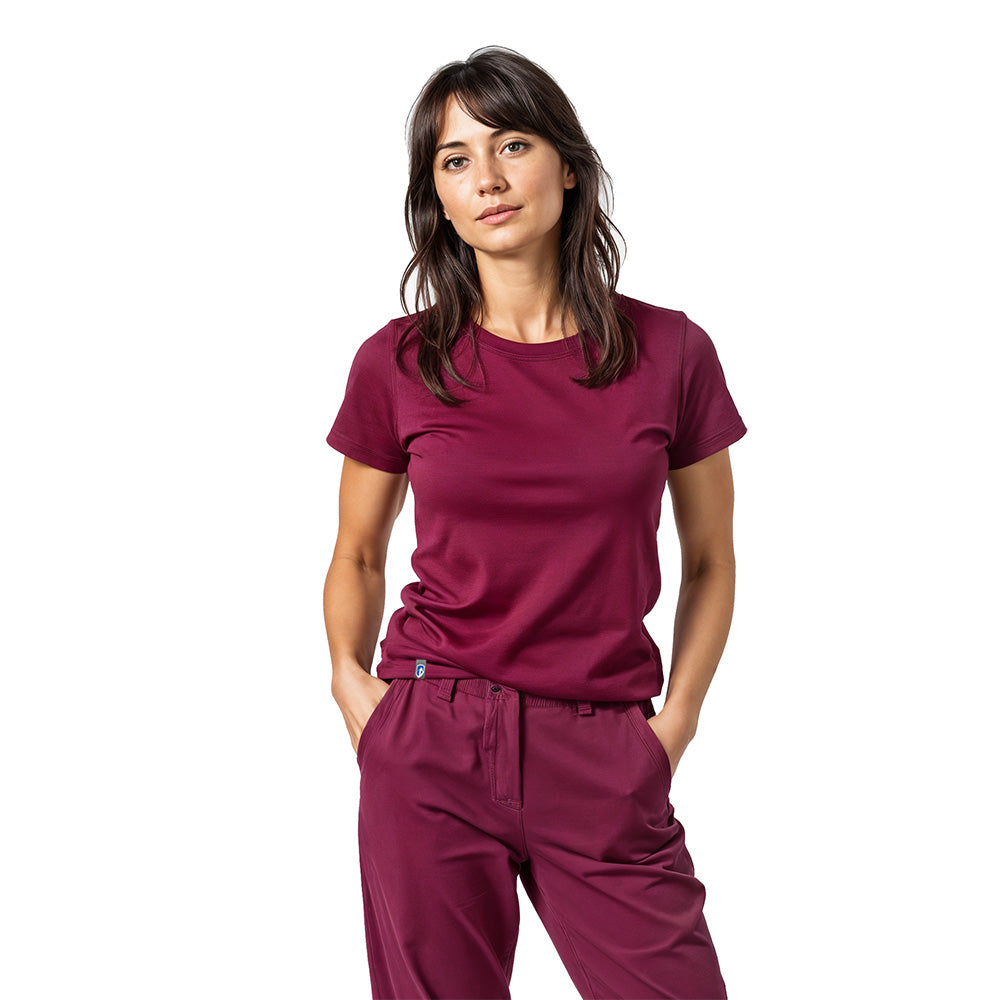 Junge Frau in burgundroten Scrubs, repräsentiert das 100% Merino T-Shirt Damen 180g/m2, ideal für Outdoor-Aktivitäten und Alltag, mit höchsten Komfort und Funktionalität.