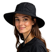 Junge Frau mit leichtem Regenhut, Alpin Loacker, aus 100% recyceltem Polyester, wasser- und atmungsaktiv, ideal für Outdoor-Aktivitäten.