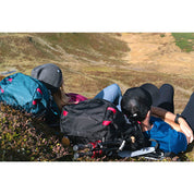 Zwei Wanderer ruhen auf einem Hügel mit dem 35 Liter Wanderrucksack Herren & Damen, ideal für Outdoor-Abenteuer, sichtbar sind Trekkingstöcke und Rucksäcke.