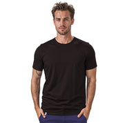 Mann trägt 100% Merino T-Shirt Herren 180 g/m2, ideal für Outdoor-Aktivitäten, gefertigt aus weicher, atmungsaktiver Merinowolle, symbolisiert Komfort und Funktionalität.